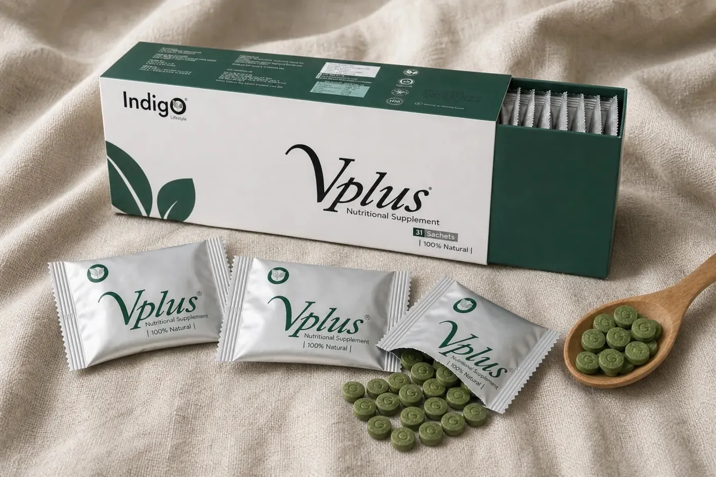 An open Vplus box with silver sachets and a wooden spoon of green tablets